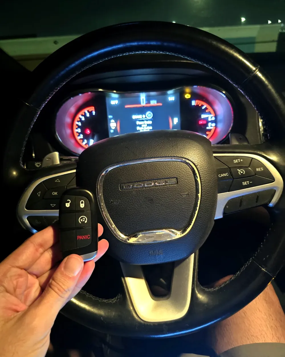 New Dodge key held at the steering wheel at night