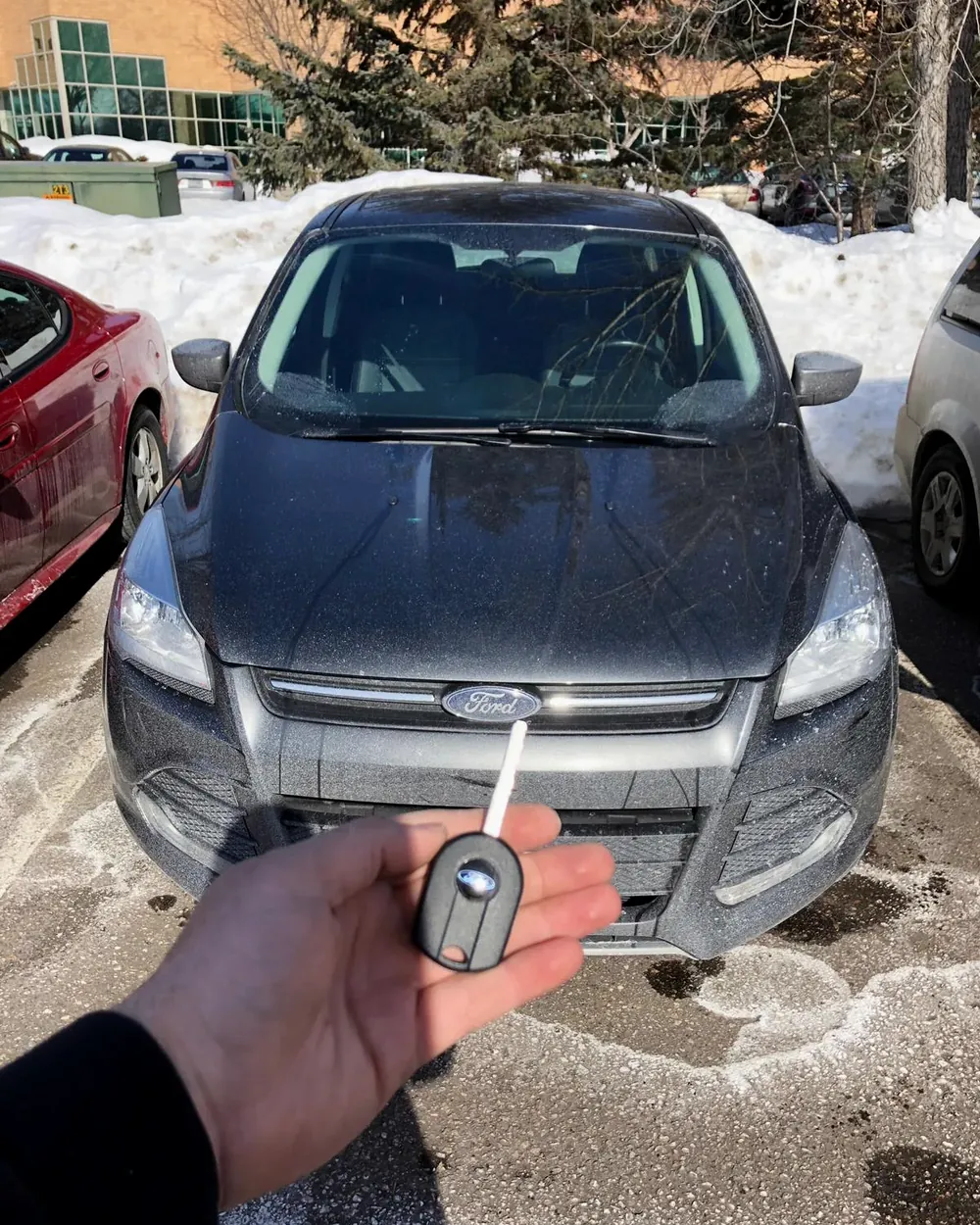 New Ford flip key held in front of the car in a winter parking lot by a locksmith serving Lynbrook, NY