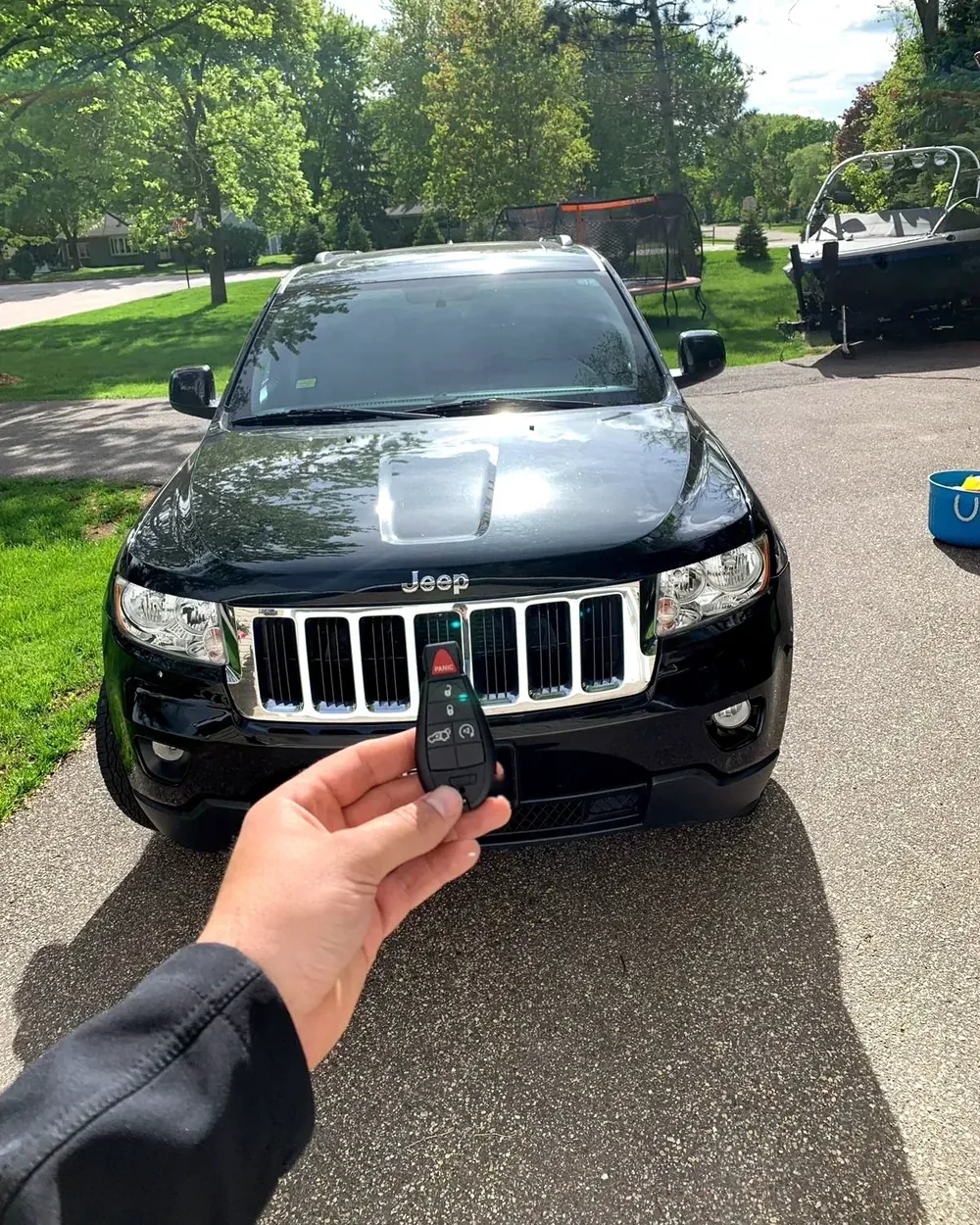 New Jeep Grand Cherokee key held in front of the car in a home driveway by a locksmith serving Franklin Square, NY