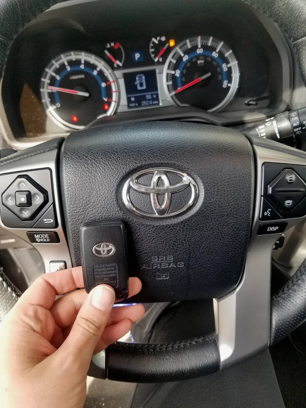 New Toyota smart key held at the steering wheel