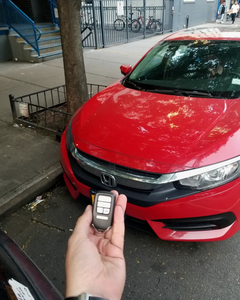 Llave inteligente nueva para un Honda Civic rojo, hecha en la calle donde estaba estacionado