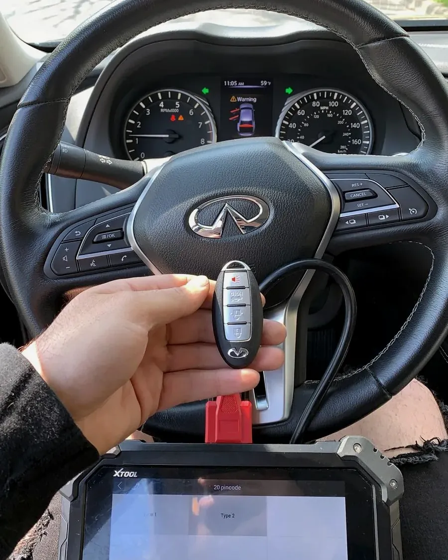 Llave inteligente de Infiniti programándose con un equipo conectado al carro