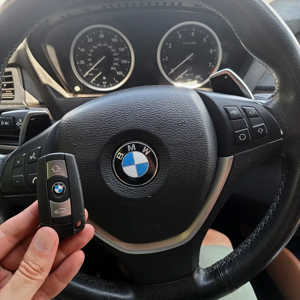 New BMW smart key held in front of the steering wheel