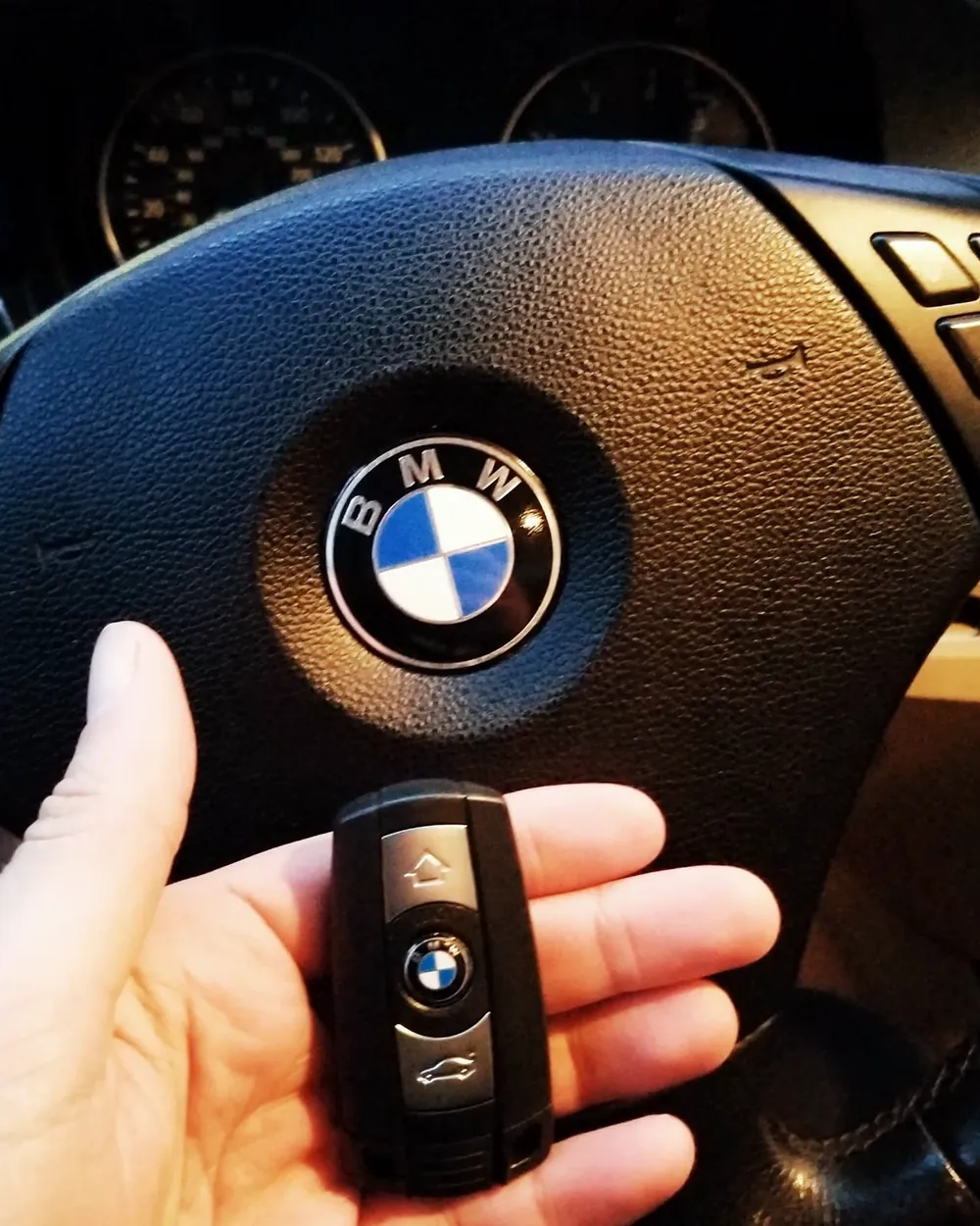 New BMW smart key held in front of the steering wheel after a job in Rockville Centre, NY